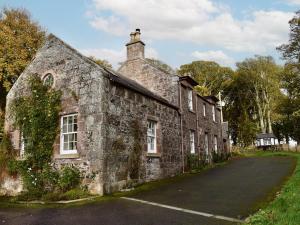 an old stone building with a street in front of it at Straton Cottage in Saint Cyrus