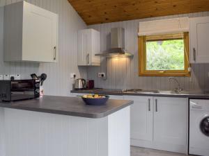 a kitchen with white cabinets and a bowl on a counter at Loch Earn View Lodge in Lochearnhead