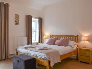a bedroom with a large bed and a window at Rowan House in Threlkeld