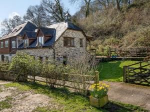 an old stone house with a metal roof at Clock Cottage in Branscombe