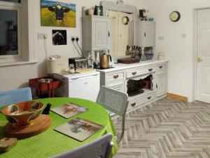 a kitchen with a green table and a stove at Altabrug in Howmore