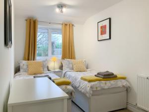 a small bedroom with two beds and a window at Sleepy Willow in Little Snoring