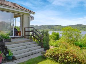 a house with stairs and a view of the water at Dunyvaig in Colintraive