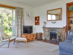 a living room with a tv and a fireplace at Dunyvaig in Colintraive