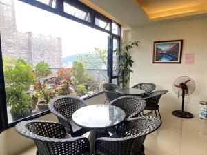 Habitación con mesas, sillas y ventana grande. en Cherry Feast Resort, en Yuchi