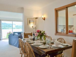 a dining room with a table with flowers on it at Dunyvaig in Colintraive