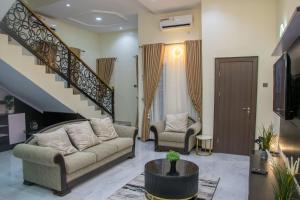 a living room with two couches and a staircase at Lake Luxury Homes in Ibadan