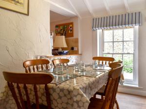 a dining room with a table with chairs and a window at September Cottage in Wells next the Sea