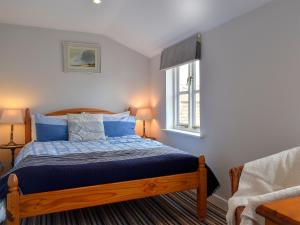 a bedroom with a bed and a window at September Cottage in Wells next the Sea
