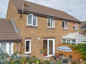 a brick house with an umbrella in front of it at Britannia Way in Westward Ho