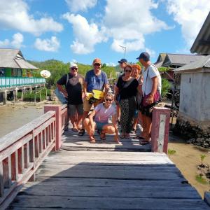 a group of people walking across a wooden bridge at Areef Homestay Kaledupa in Kaledupa