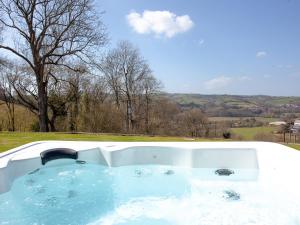 a jacuzzi tub with a view of a field at The Cow Shed in Tiverton