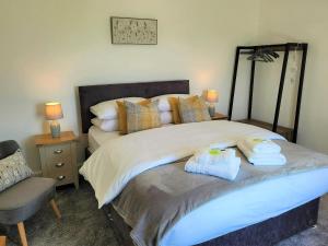 a bedroom with a large bed with towels on it at Garrarie Cottage in Monreith