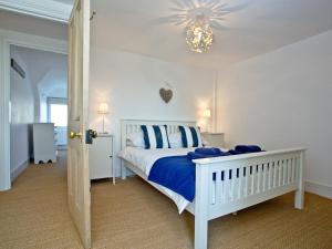 1 dormitorio con cama blanca y lámpara de araña en Anchor Loft, en Fowey