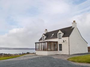 a white house with a black roof on a road at Hillside - Uk32930 in Gairloch