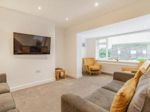 a living room with a couch and a tv at Broadacre House in Brixham