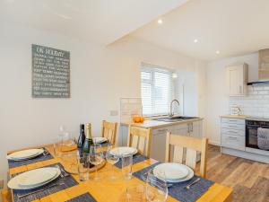 a kitchen with a table with plates and wine glasses at Broadacre House in Brixham