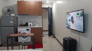 a small kitchen with a table and a television on the wall at Seaview and Cityview Mactan,Cebu in Lapu Lapu City