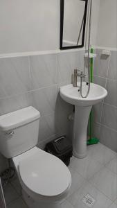 a bathroom with a white toilet and a sink at Seaview and Cityview Mactan,Cebu in Lapu Lapu City