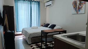 a small room with a bed and a sink at Seaview and Cityview Mactan,Cebu in Lapu Lapu City