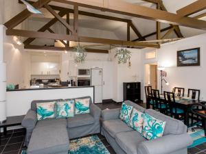 a living room with two couches and a kitchen at The Boathouse in East Cowes