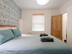 a bedroom with a large bed with towels on it at The Boathouse in East Cowes