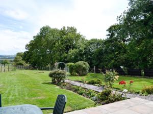 Brae Cottage في Kelton: اطلالة على حديقة بها ورد واشجار
