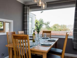 a dining room with a table and chairs and a window at Woodpeckers Rest in Niton