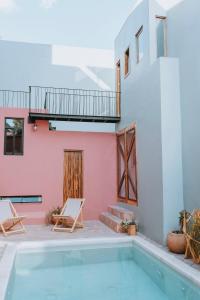 una piscina con 2 sillas y una casa en Hotel Boutique Casa de Arte Oaxaca, Art Gallery & Pool, en Oaxaca City