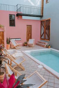 eine Terrasse mit einem Pool und Stühlen sowie ein Haus in der Unterkunft Hotel Boutique Casa de Arte Oaxaca, Art Gallery & Pool in Oaxaca de Juárez