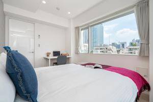 a white bedroom with a large window and a bed at ZAITO Tokyo Skytree Yokokawa III 錦糸町駅から徒歩９分 in Tokyo