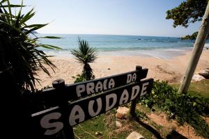 ein Straßenschild am Strand mit dem Meer in der Unterkunft Chalé do Litoral in Penha