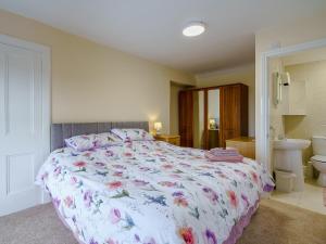 a bedroom with a bed with a floral bedspread at Margaret House in Chirnside