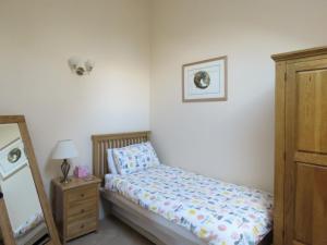 1 dormitorio con cama, tocador y espejo en Dippers Folly, en Buckland Dinham