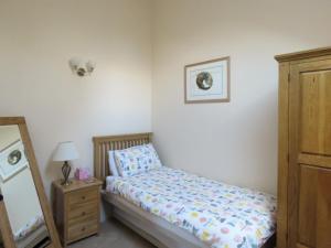 a bedroom with a bed and a dresser and a mirror at Dippers Folly in Buckland Dinham