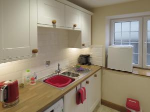 cocina con fregadero y fregadero rojo en Dippers Folly, en Buckland Dinham