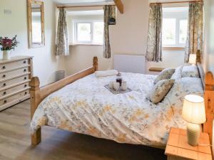 a bedroom with a bed and a table and two windows at Bryn Eithin in Moel-tryfan