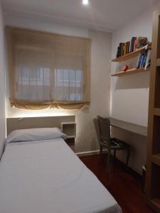a bedroom with a bed and a desk and a window at Bonito piso 4 habitaciones en Bétera in Bétera