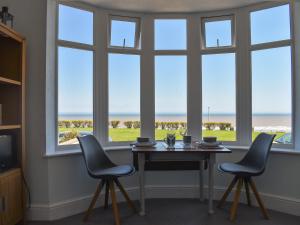 a table and two chairs in front of a window at Wild Waves in Hornsea