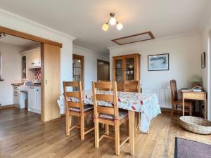 a kitchen and dining room with a table and chairs at Taigh Nan Eilean in Valtos