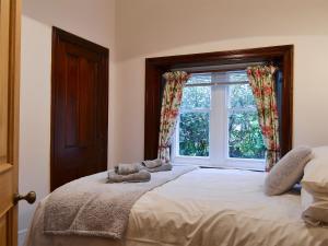 a bedroom with a large bed with a window at Lealholme in Bassenthwaite