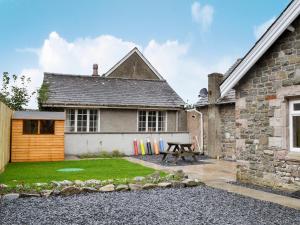 un patio trasero con una mesa de picnic y una casa en Lealholme, en Bassenthwaite