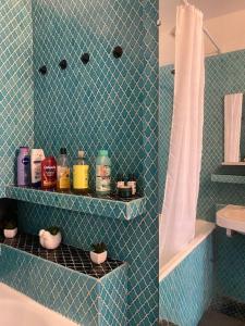 La salle de bains est pourvue de carrelage bleu, d'une douche et d'un lavabo. dans l'établissement Vue imprenable sur la Tour Eiffel ! Appartement Grand Standing Porte de Paris, à Villejuif