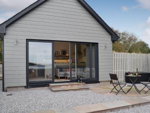 ein Haus mit einer großen Glasschiebetür in der Unterkunft The Nook At Balcary in Auchencairn