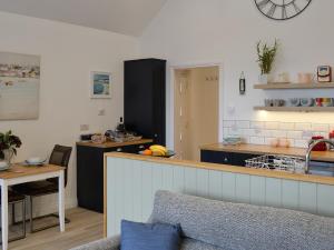 eine Küche mit einer Theke und einem Tisch in einem Zimmer in der Unterkunft The Nook At Balcary in Auchencairn