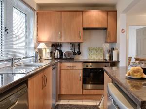 a large kitchen with wooden cabinets and a sink at Ruach in Gardenstown