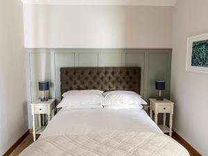 a bedroom with a large bed with two night stands at The Barn At Daubeneys in Colerne