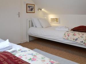 a bedroom with two beds with white sheets at Ruach in Gardenstown