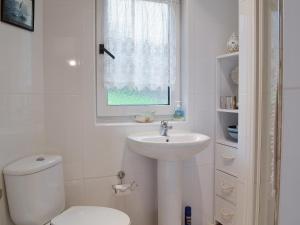 een witte badkamer met een toilet en een wastafel bij Ruach in Gardenstown