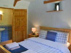 a bedroom with a bed and a bathroom with a sink at Coachmans Retreat in Saint Kew